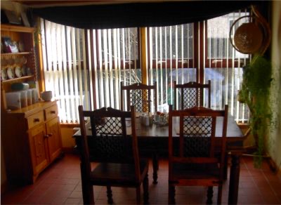 Table and chairs beside tall window blinds